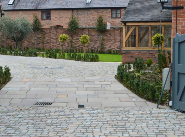 Courtyard garden with natural stone paving and cobble driveway