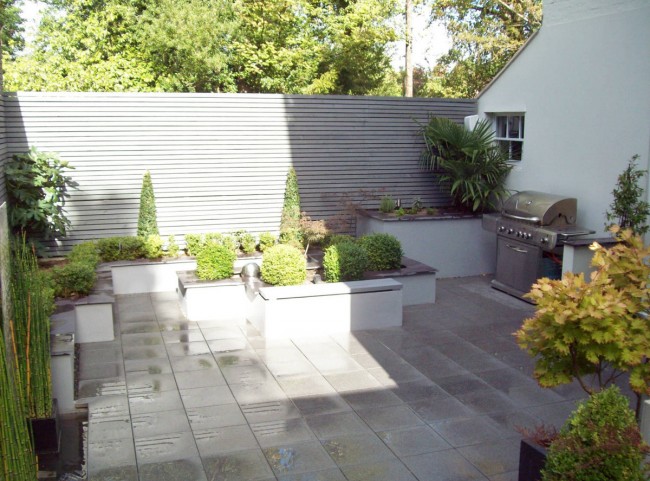 Courtyard garden with raised borders and painted slatted trellis 