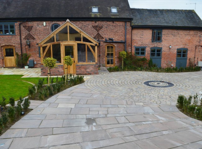 Courtyard garden with natural stone paving and circular cobbled detail