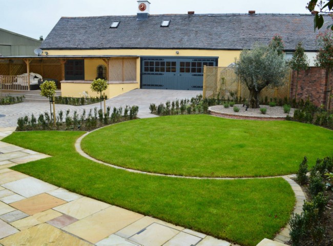 Courtyard garden with circular lawn with olive tree